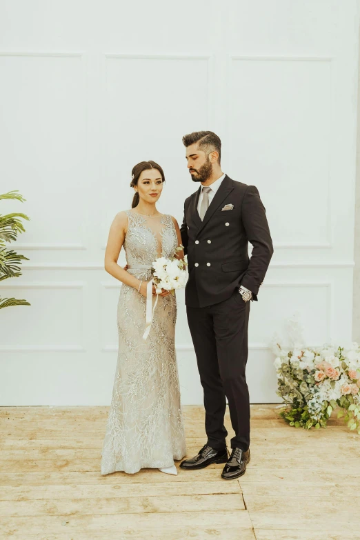 two people stand next to each other, dressed in wedding attire