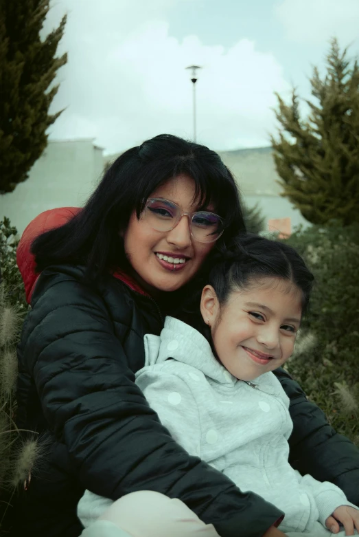 a woman holding a little girl in her arms