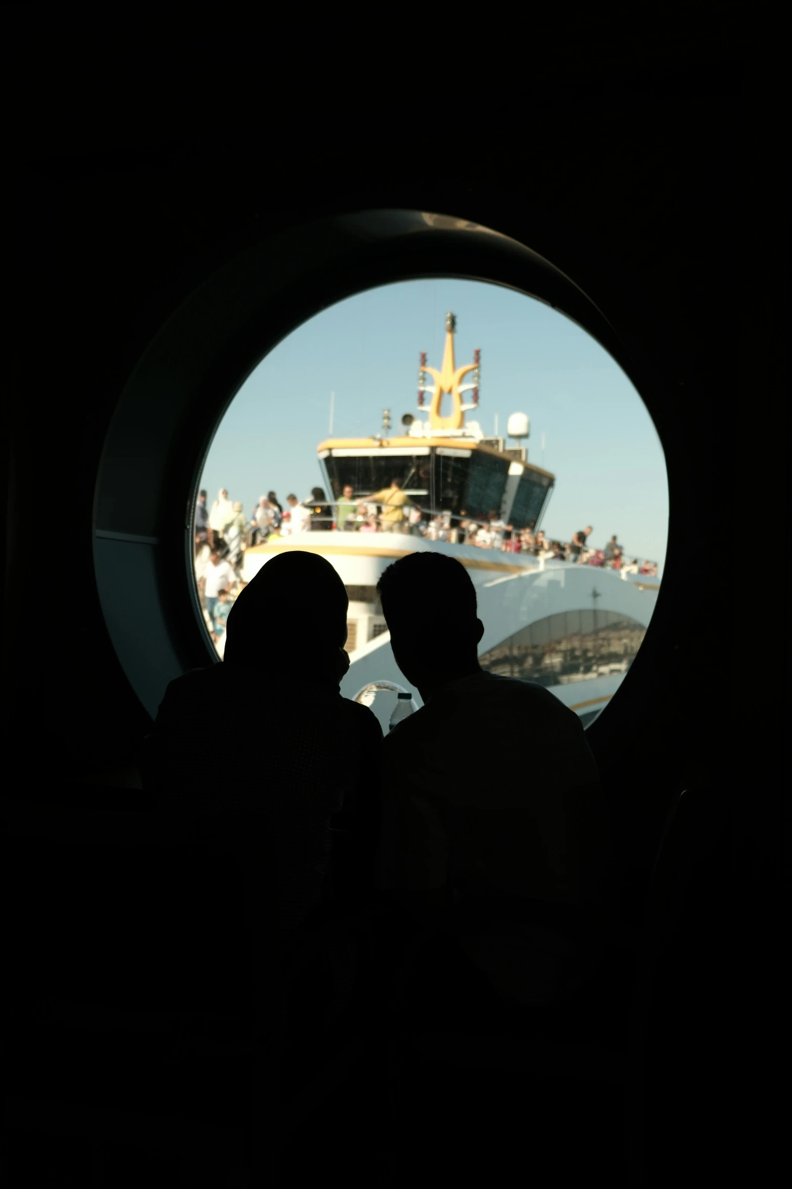 people looking out of a porthole on a ship