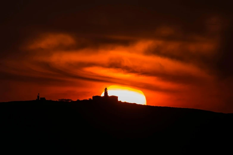 a sun is setting on the horizon over some clouds