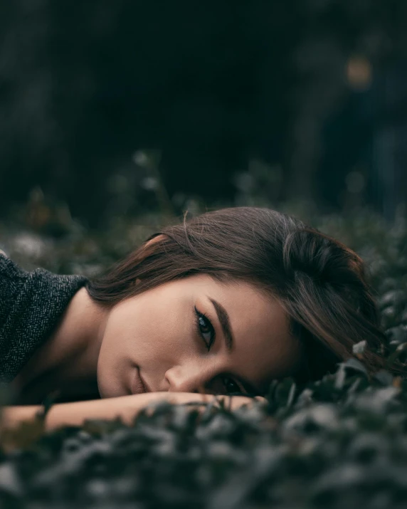 a woman in black sitting in a grassy area