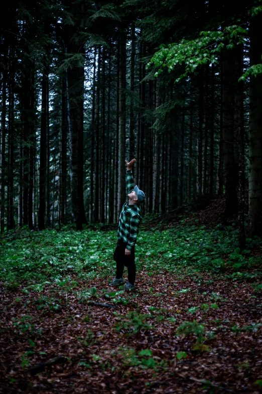 man standing in the middle of woods and posing for a po