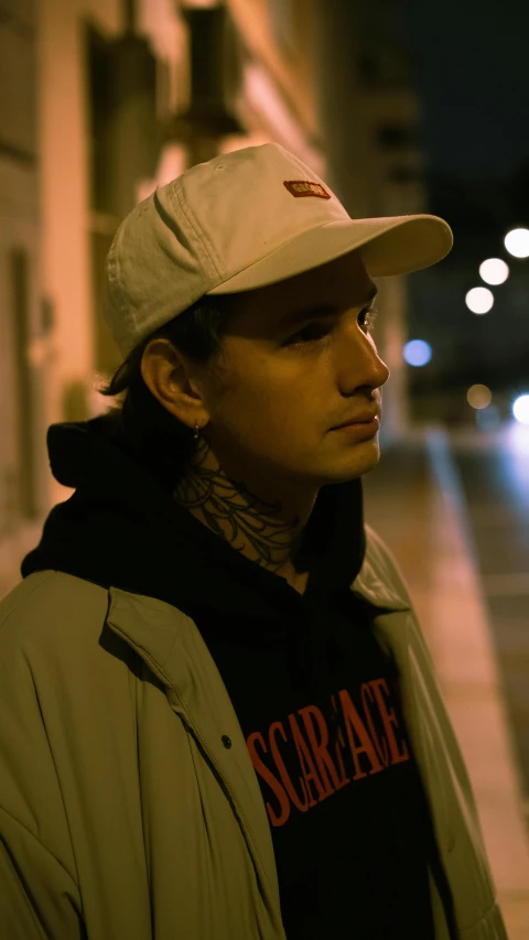 a man standing in the street wearing a hat