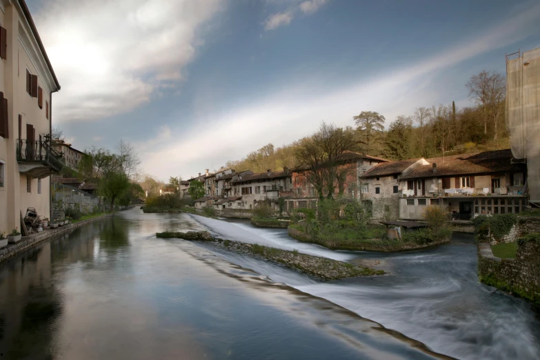 a river next to a building with two balconies on each side