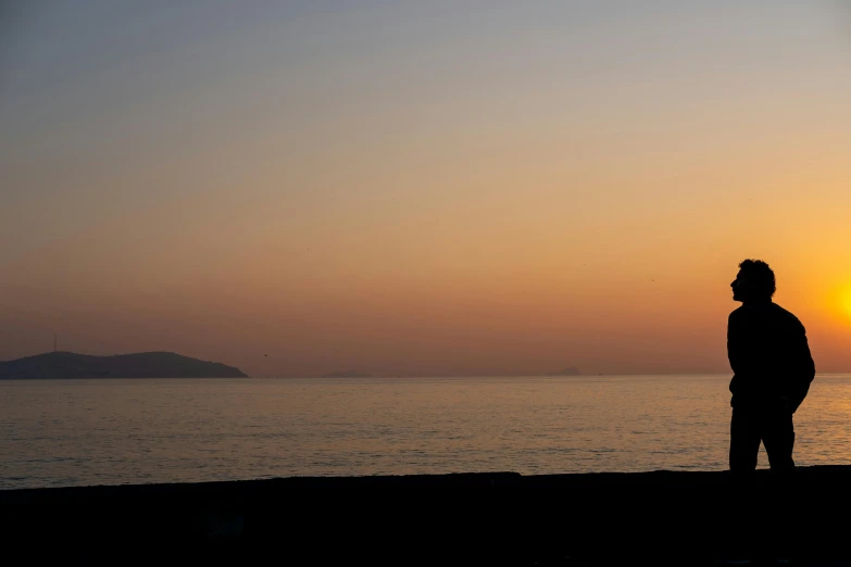 a man that is standing next to the ocean