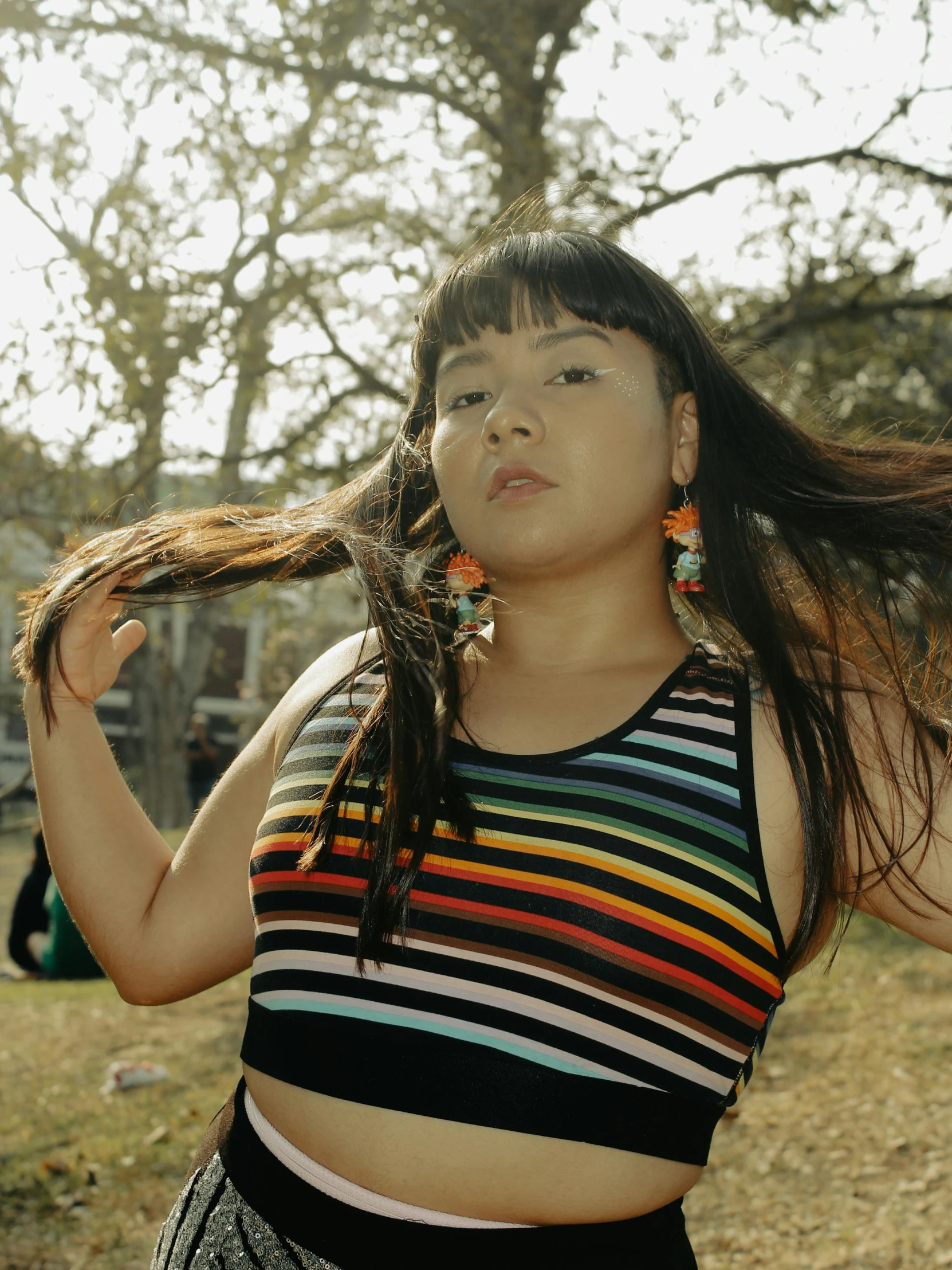 an asian woman with long hair outside in a park