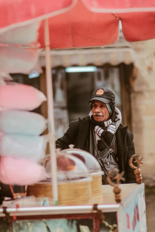 the man is wearing ear phones as he walks near an outdoor display