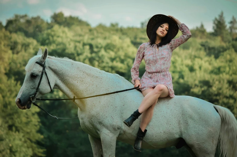 a woman sitting on top of a white horse