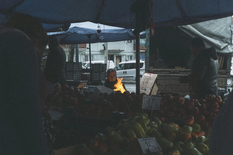 an outdoor market with fruit, vegetables and an umbrella