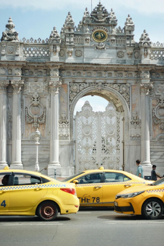 taxis parked on the side of the street in front of an ornate entrance