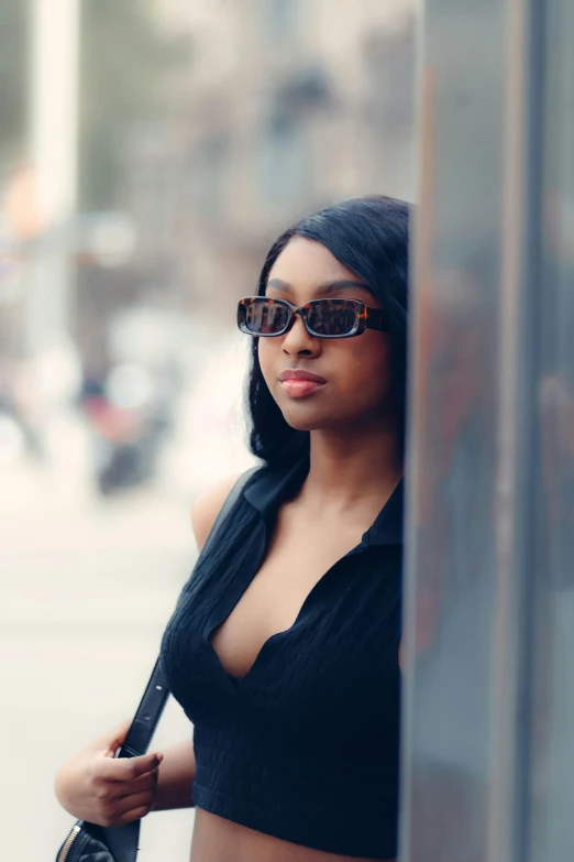 a woman is posing for the camera, in black and brown sunglasses