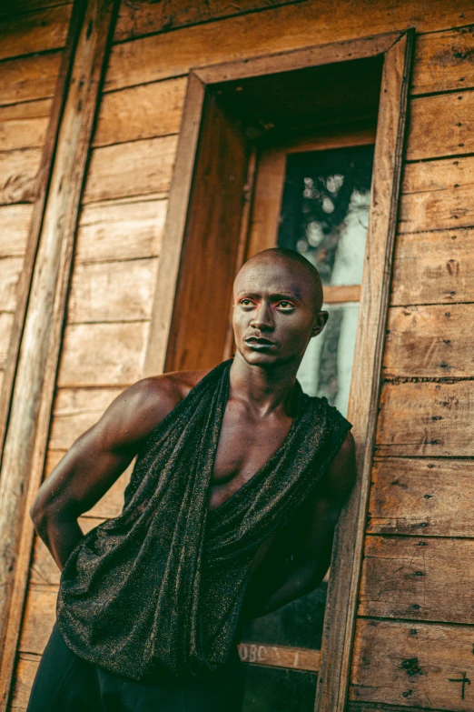 man leaning on wooden structure with open door