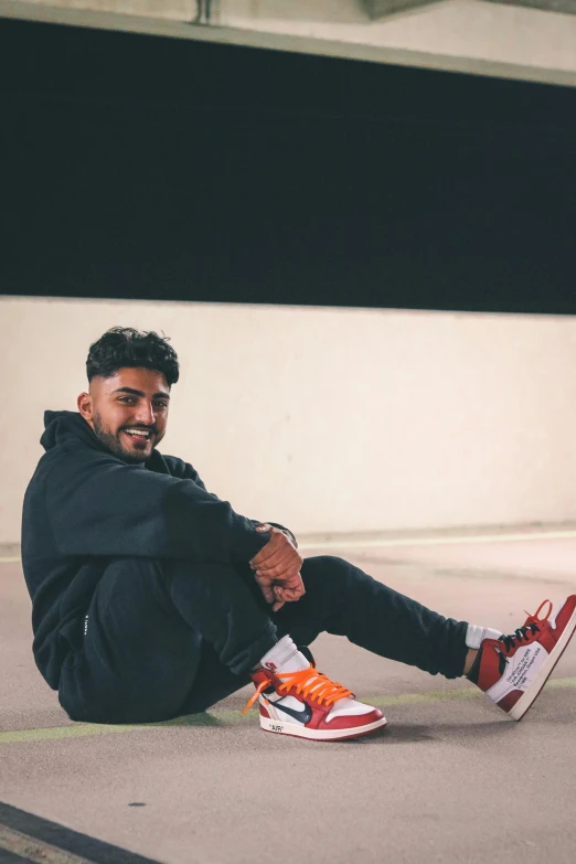 a man sitting on the ground wearing his sneakers