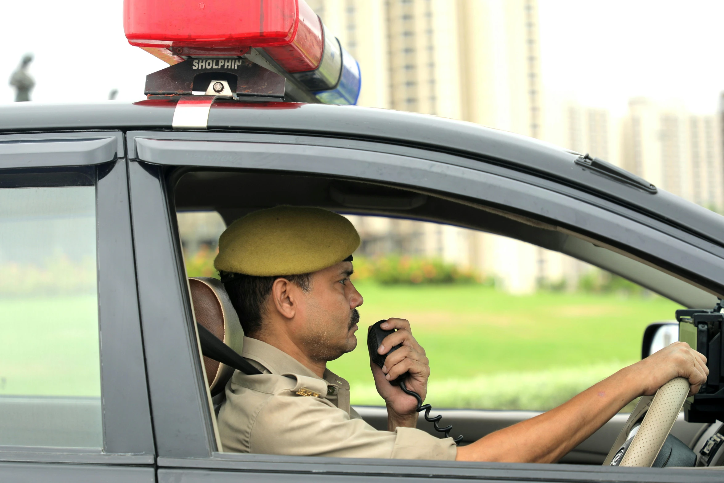 a police officer holding a phone up to his ear in his vehicle