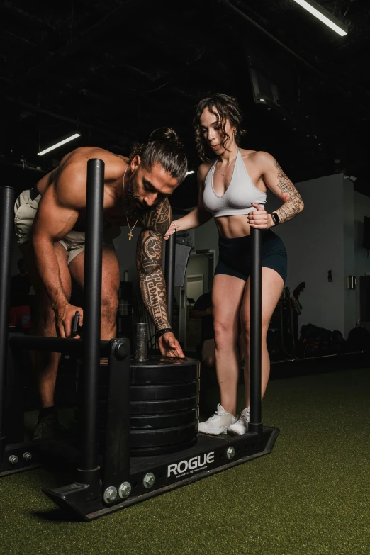 a man and woman in an indoor gym setting on stationary equipment