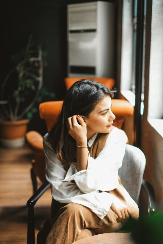 a woman sitting on a chair talking on her phone