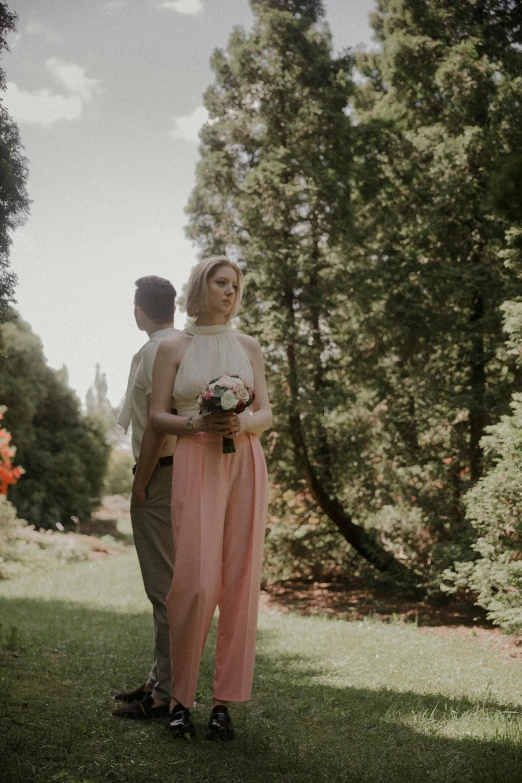 a couple posing for a pograph in the grass