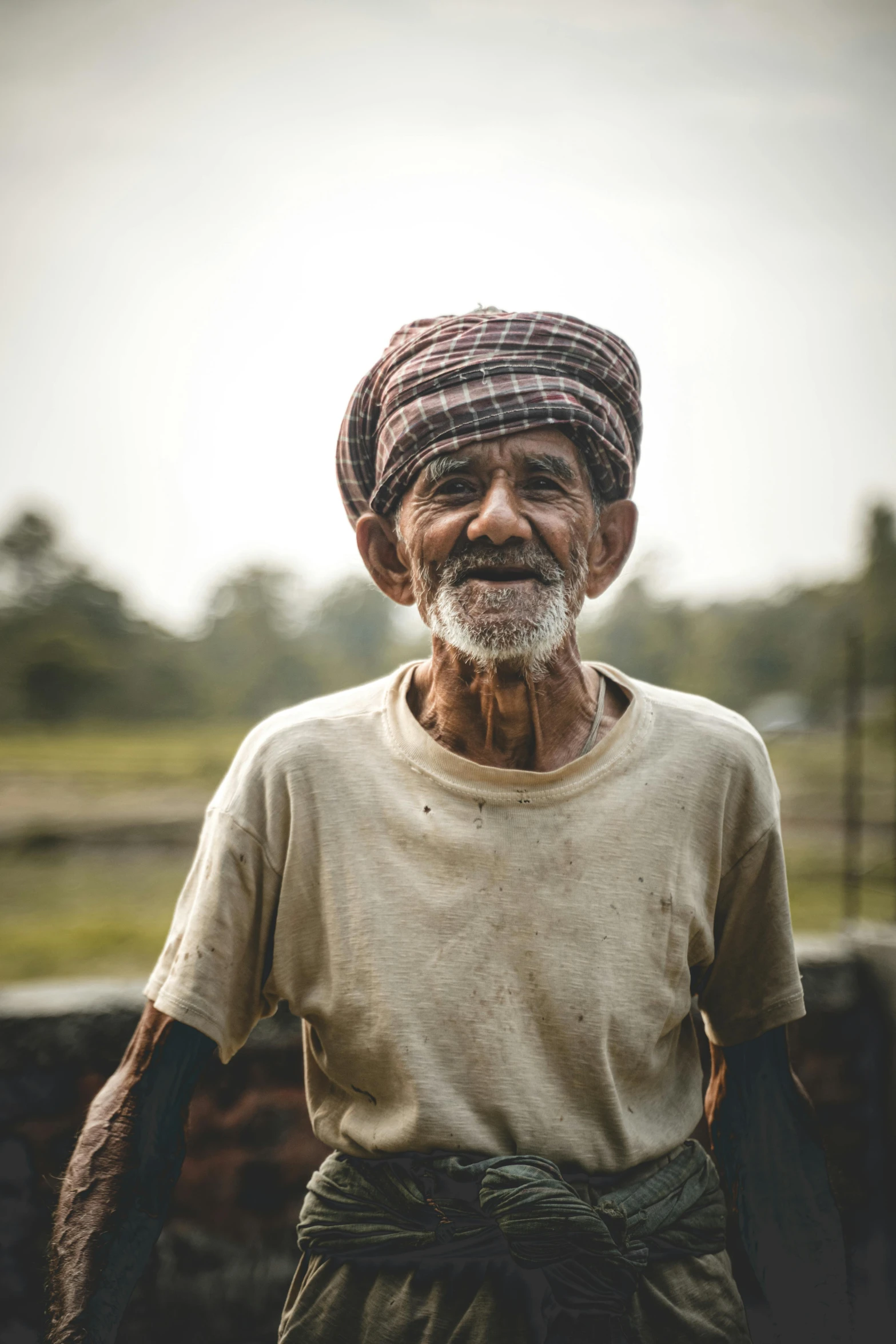 an old man standing in front of a fence