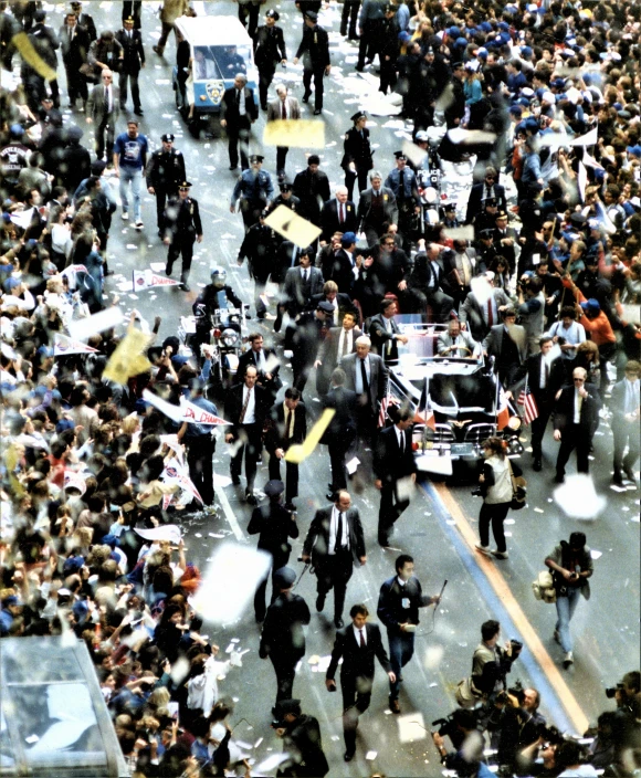 a large group of people and police walking in a parade