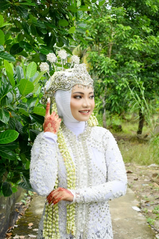 a woman dressed in an oriental costume poses with her hands together