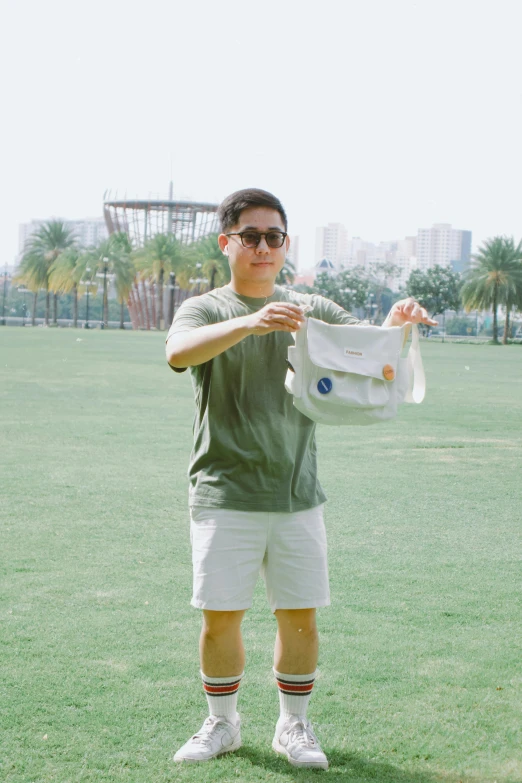 a young man standing on top of a lush green field