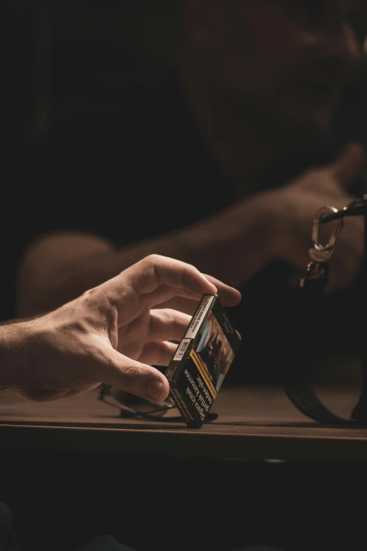 a person sitting with their hand on the table next to a cup