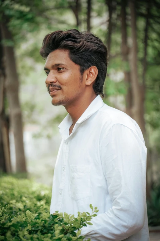 a man that is standing in front of some trees