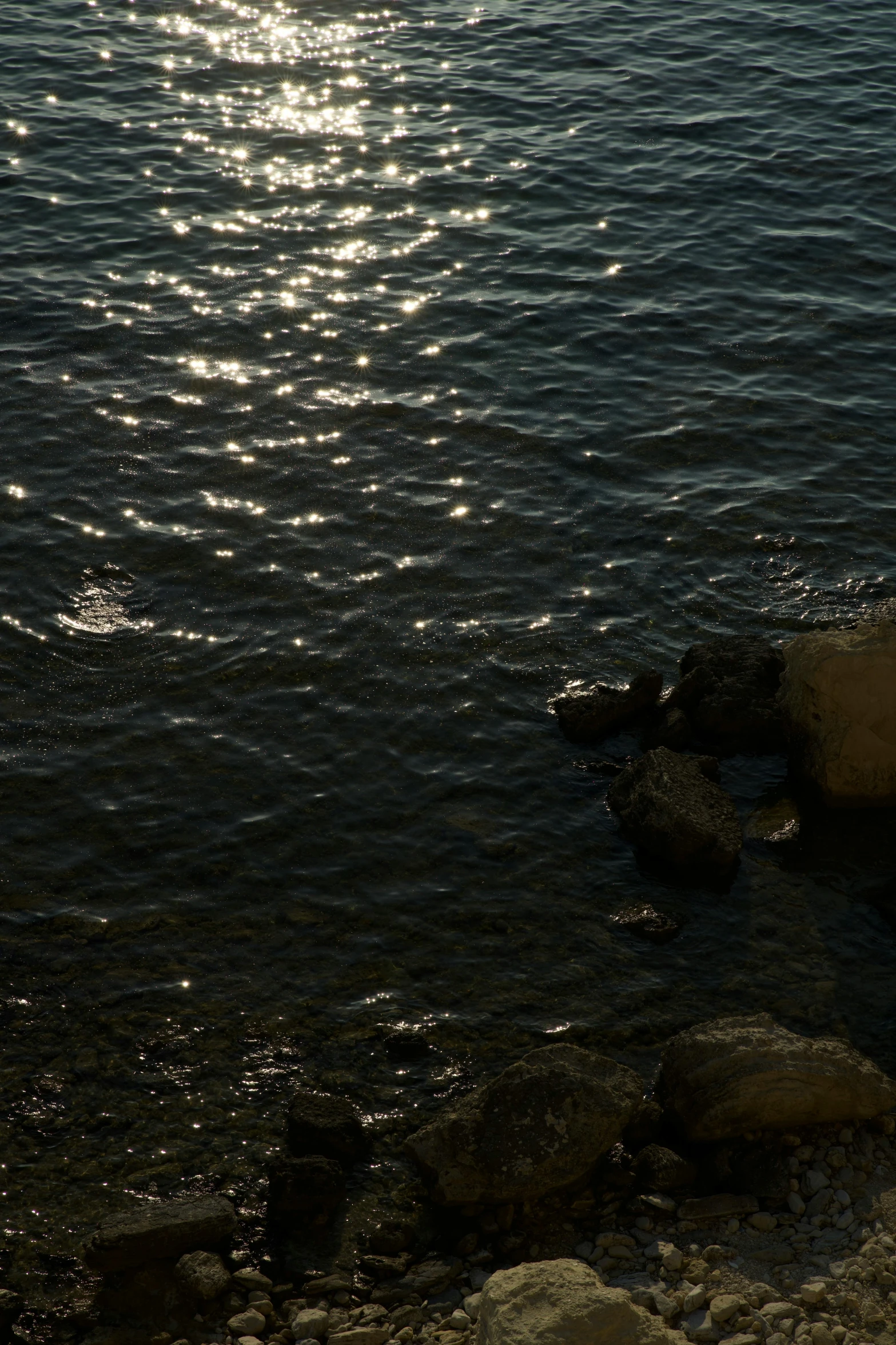 the sun shines brightly over water on the shore