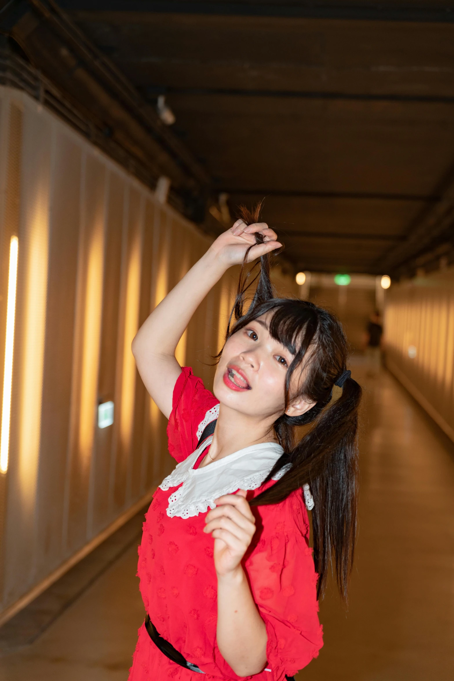 young woman in red dress looking to her left posing for po