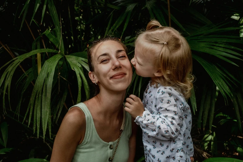 a woman in a white shirt holding a small child