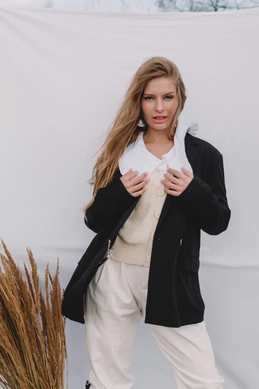 a woman in a white and black jacket holding a brown plant