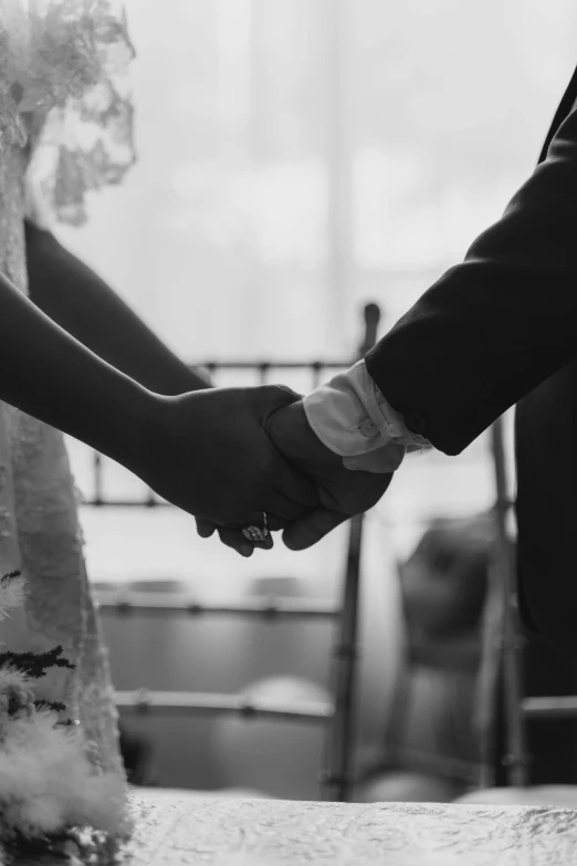 two people holding hands together as if they are married