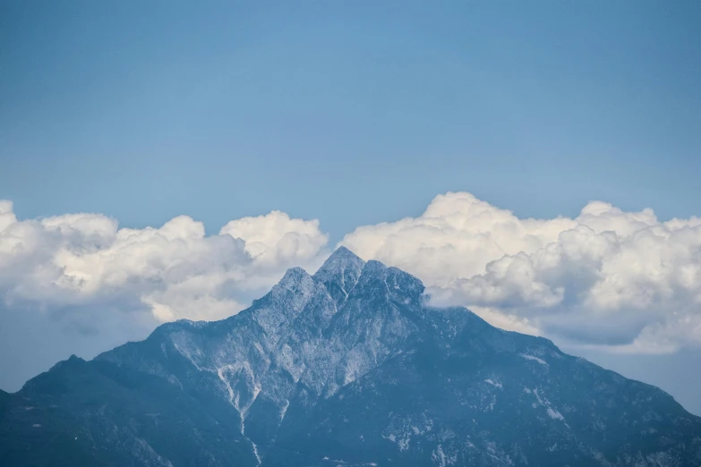 some clouds sitting in the sky above some mountains