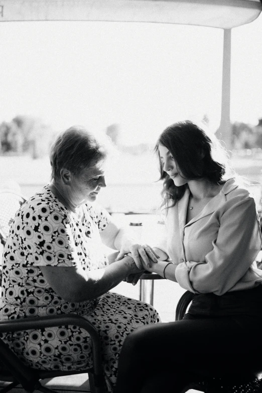 a lady and a woman sitting together outside