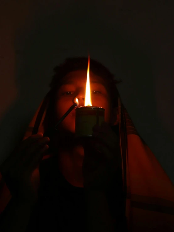 the person holding a cell phone is lit up with a lighter