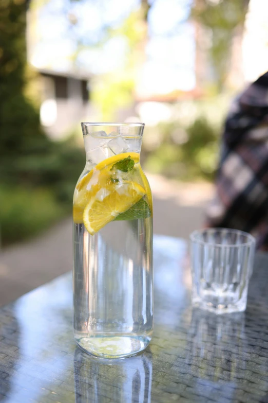 a pitcher of lemon water sitting on top of a table