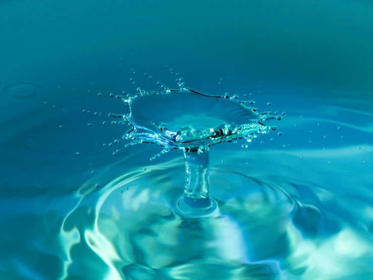 a water drop is in clear blue liquid