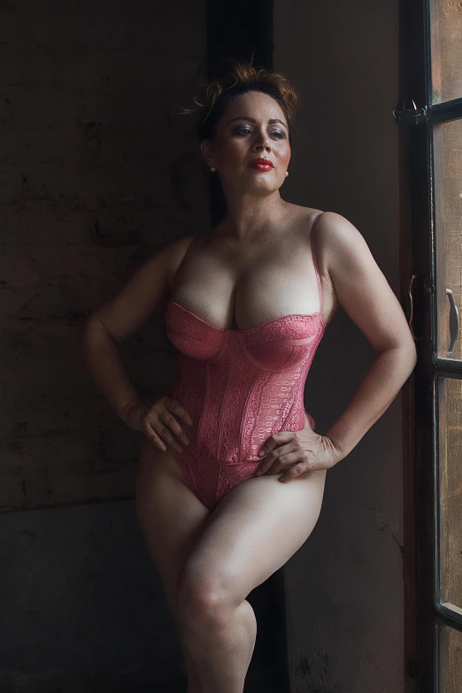 a  woman is posing in a pink lingerie