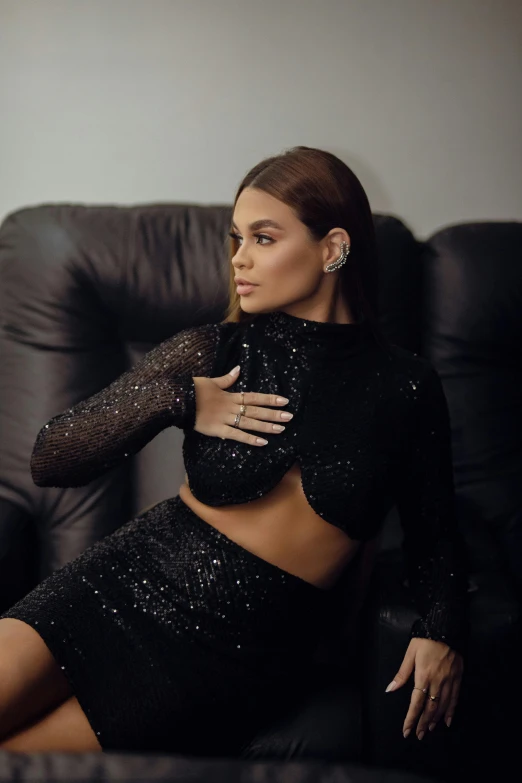 a woman posing on a black couch
