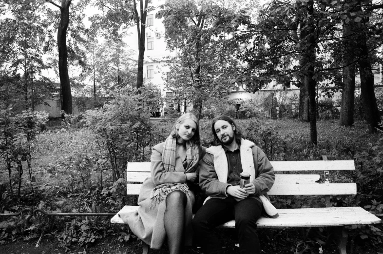 a man and woman sit on a park bench