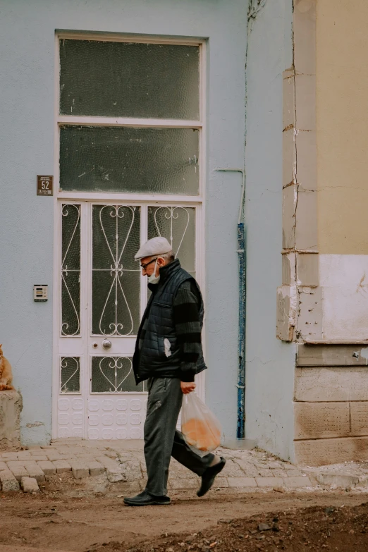 the man is walking down the street with his bag