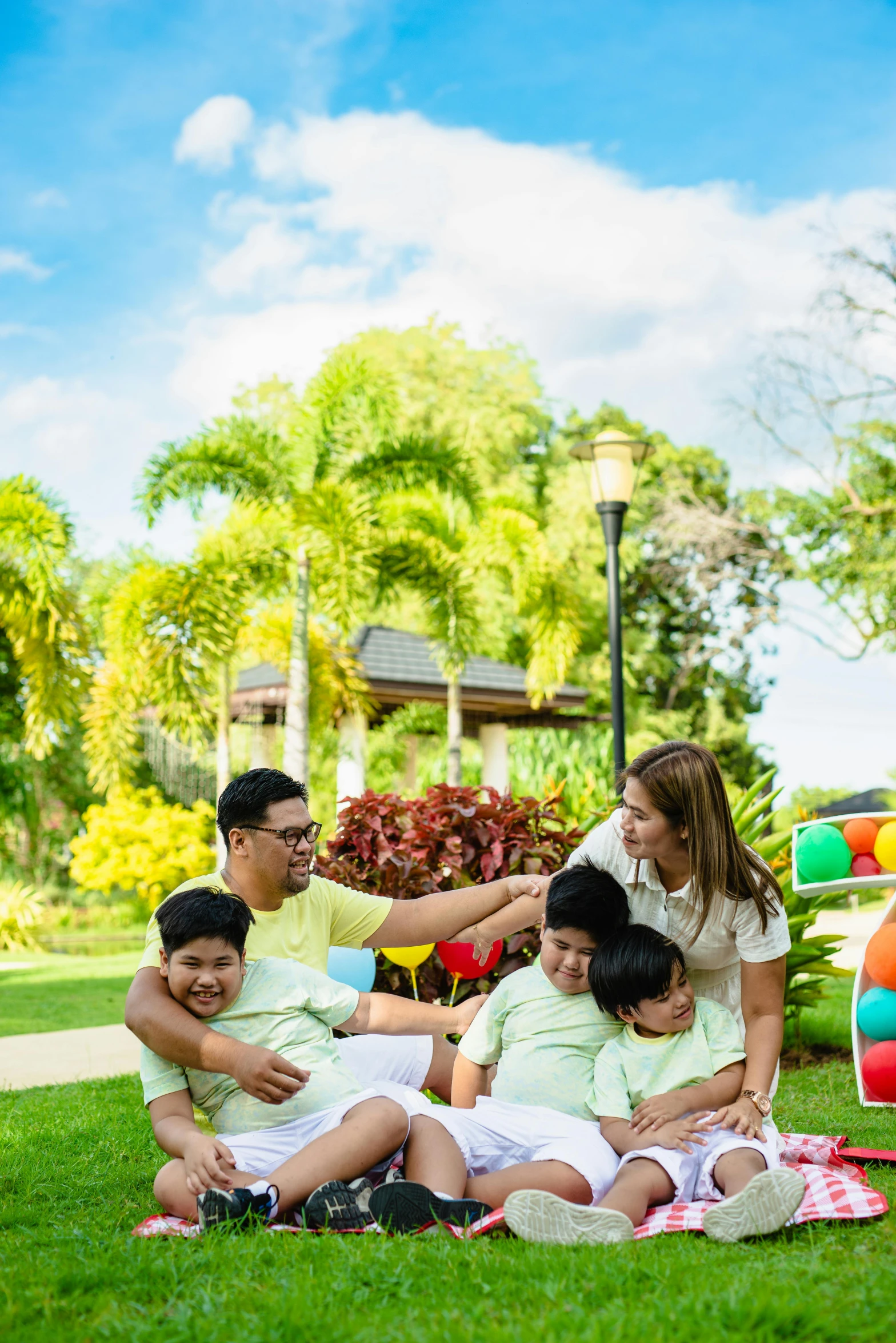 a family is sitting on the grass together