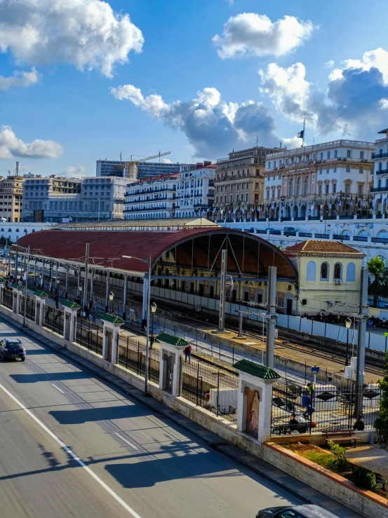 a very busy city street with a train pulling up to it's terminal