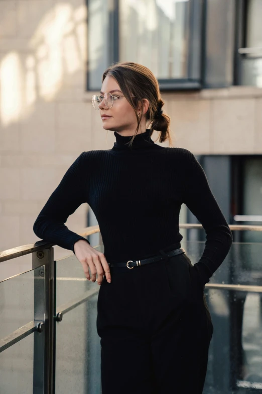 a woman in black pants standing near railing