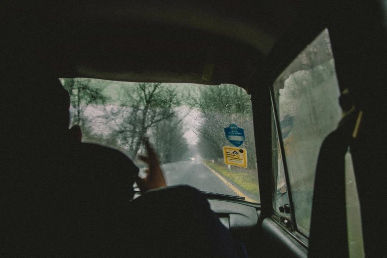 a view of a rain soaked street from inside a car