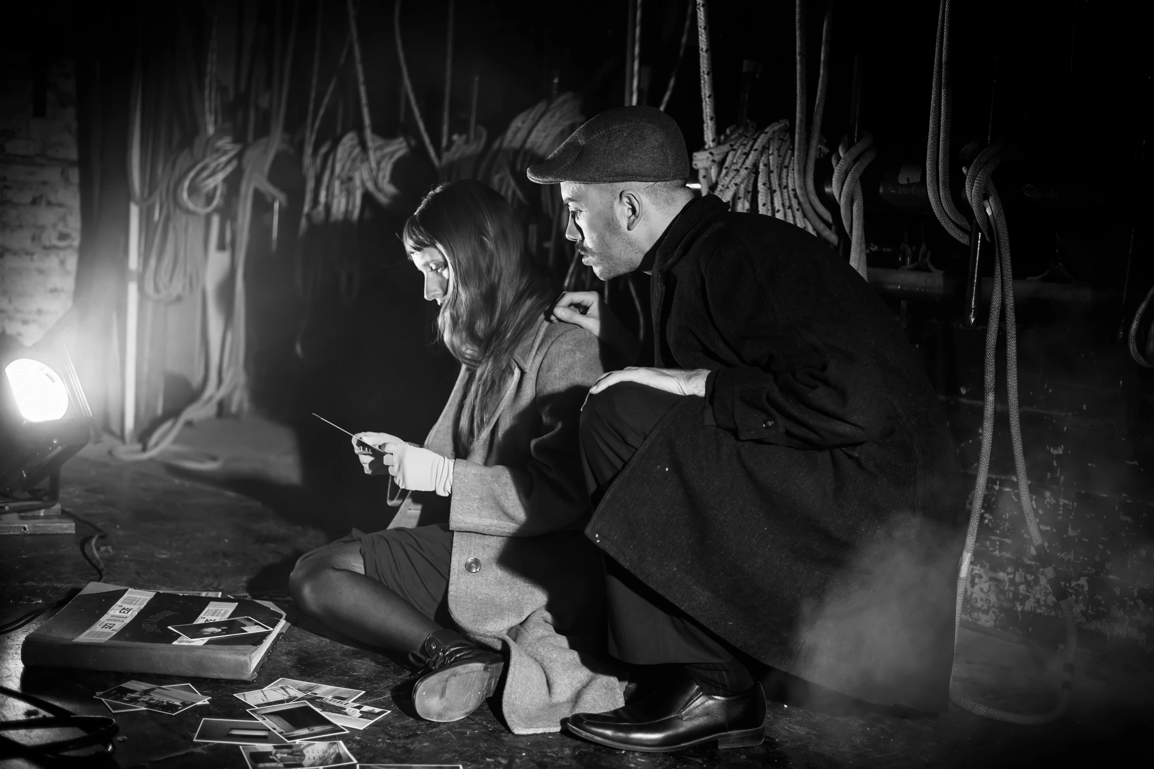 man and woman with cell phone on floor of room