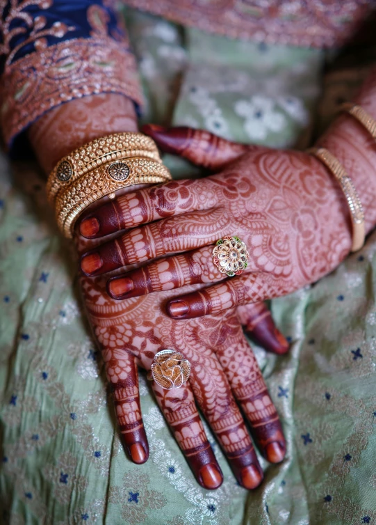 an indian woman holding out her hands with two rings on top