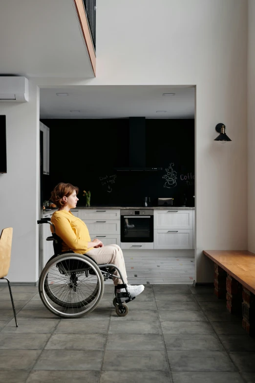 a man in a wheel chair is looking towards a kitchen