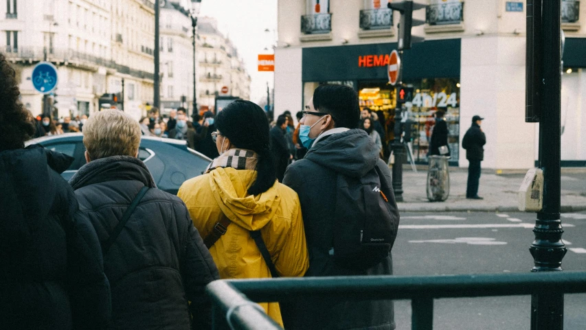 a couple of people are standing near each other on a sidewalk