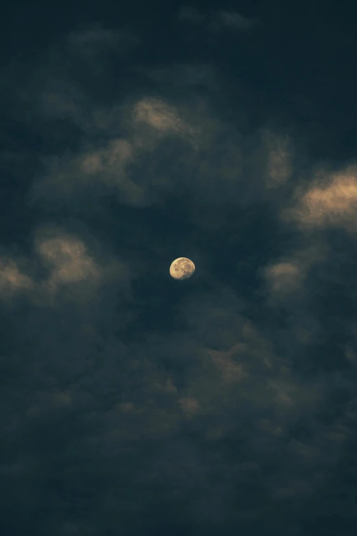 a full moon is shown in the sky above clouds